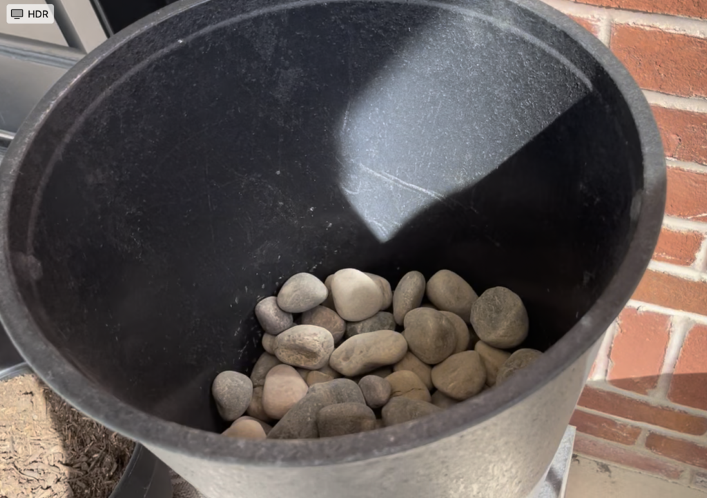 Filling the bottom of the pot with river rocks add weight to the porch planters keeps them from blowing over in the wind. 